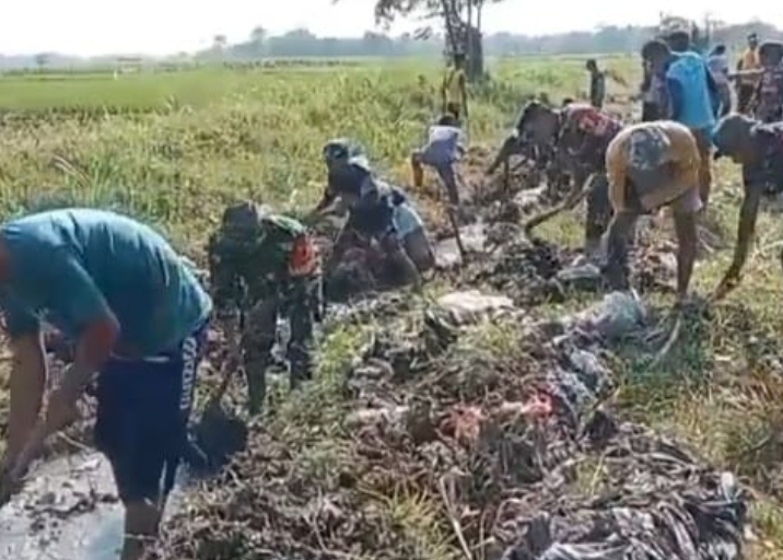 Anggota Koramil Panji Bersinergi Kerja Bakti Bersama Masyarakat Bersihkan Sampah di Saluran Irigasi