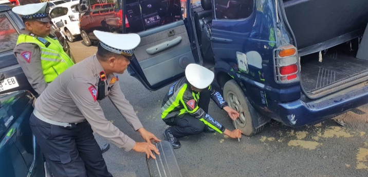 Personil Lantas Polres Bondowoso Bantu Mobil Rombongan Acara Manasik Haji yang Alami Pecah Ban