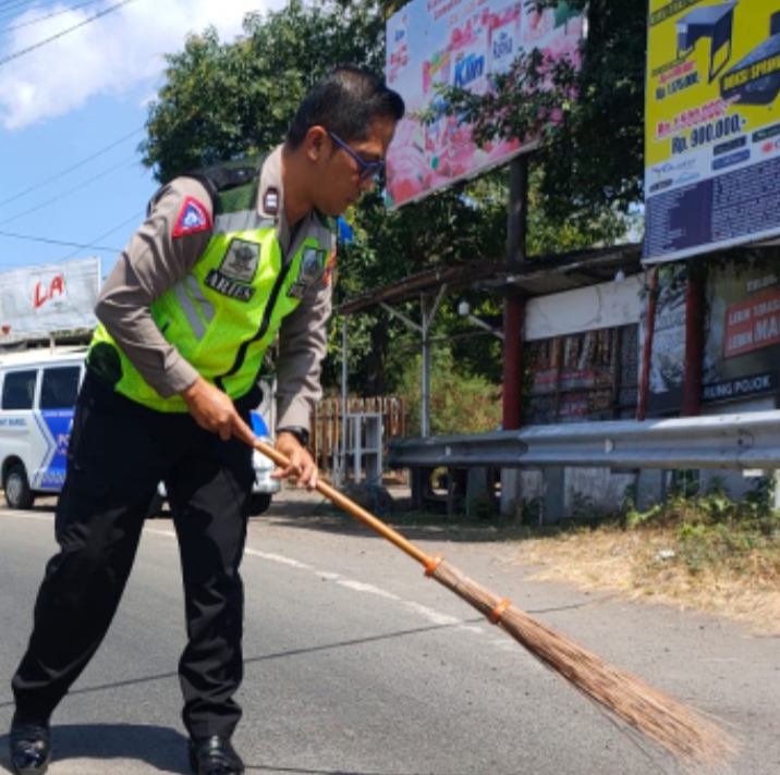 Polisi Bersihkan Pasir dan Kerikil di Jalan Raya Kotakan Situbondo